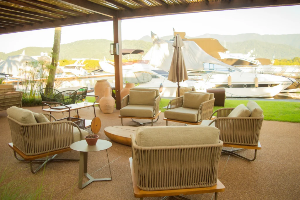 A imagem mostra uma visão de dentro do restaurante La Marina, na Marina Guararu, em um dia ensolarado.